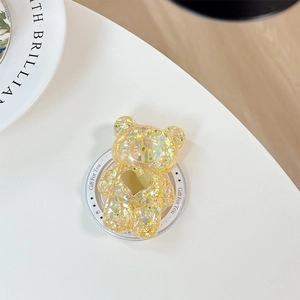 Détail macro du support de téléphone ours pailleté jaune avec sequins étincelants