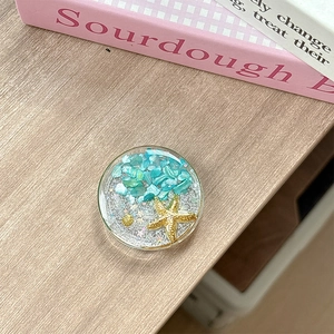Close-up of resin phone socket featuring blue stones with gold starfish and shell