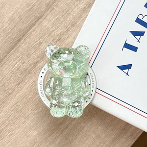 Detail of glitter bear phone grip with star sequins on a wooden background