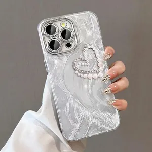 Close-up of pearl and diamond heart charm on silver brushed texture iPhone case