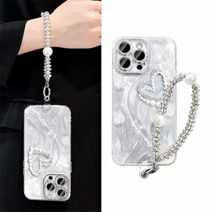 Détail de la coque iPhone avec motif cœur en perles et dragonne en strass brillant