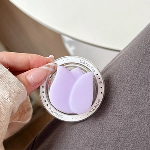 Nahaufnahme der lila Tulpen MagSafe Handyhalterung mit Gift For You Aufdruck in der Hand