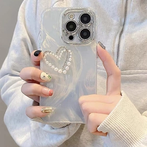Close-up of iPhone case with luxury pearl heart and rhinestone inlay held by a model