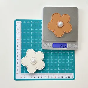 Detail showing pearl flower phone grip size of 6.5cm and weight of 23.2g on scale