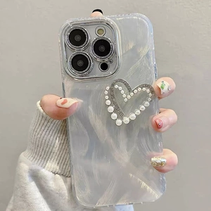 Detail of pearlescent iPhone case featuring a luxury pearl heart and sparkling crystals
