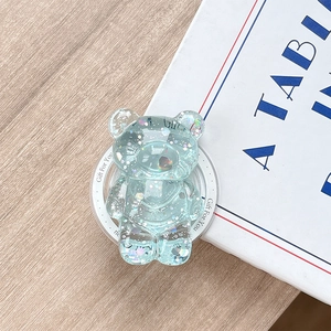 Close-up of a blue glitter bear phone socket with Gift For You text on a wooden desk
