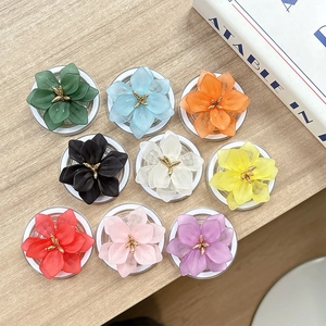 Vue à plat de neuf supports de téléphone en résine mate en forme de fleurs colorées