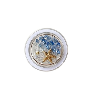 Magnetic ocean themed phone grip featuring blue stones and golden starfish on white background