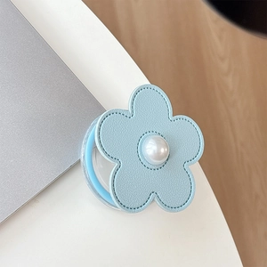 Macro shot of light blue leather flower phone socket with pearl and stitching detail