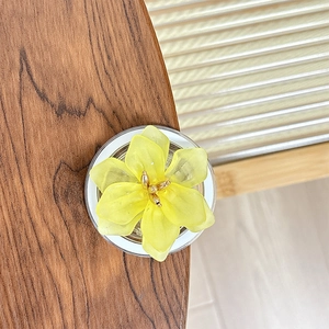 Détail du support de téléphone fleur jaune avec perles dorées sur bois rustique