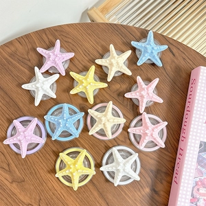 3D realistic starfish phone socket stands in various macaron colors on a wooden table