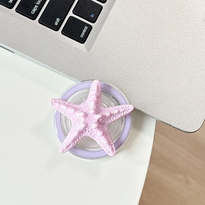 Close-up of a 3D starfish phone grip with realistic texture on a white desk