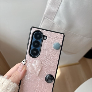 Gros plan sur coque de téléphone en cuir rose avec cœur 3D et design pliable chic