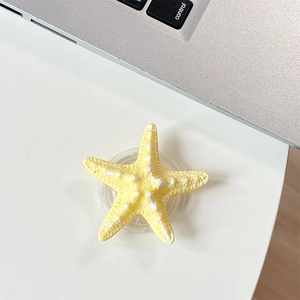Detail showing 3D yellow starfish phone socket with textured surface on a white desk