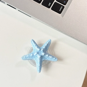 Macro shot of 3D blue starfish phone grip with textured surface on a white desk