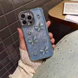 Detail of glittery blue iPhone case featuring 3D bowknot butterflies and rhinestones