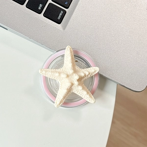 Detailed view of 3D starfish phone grip with textured surface on a desk with laptop