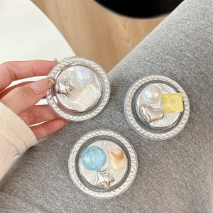 Three Korean-style phone Griptoks with star, heart, and pearl accents on gray knit