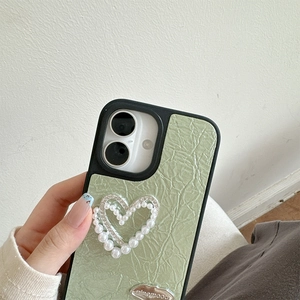 Dettaglio della custodia in pelle verde chiaro con cuore di perle e strass luccicanti