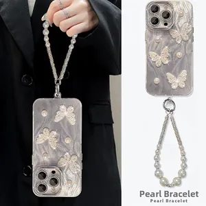 Detail of silver phone case with rhinestone butterfly and pearl wrist strap for iPhone