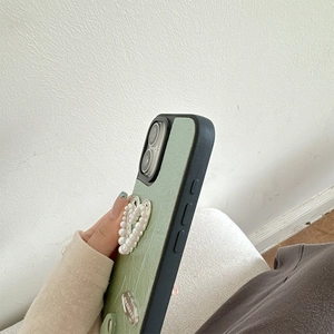 Dettaglio della cover in pelle verde menta con cuore di perle e targhetta argento