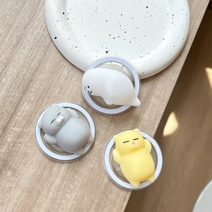 Cute squishy animal phone socket featuring cat and seal designs on a wooden table