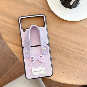 Macro detail of lavender litchi leather foldable phone case with bow and wrist strap
