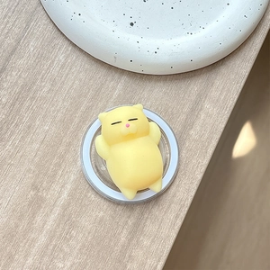 Detailed view of yellow cat-shaped squishy toy on transparent circular phone grip base