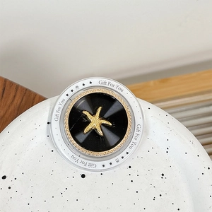 Detail of magnetic phone grip featuring a gold starfish and Gift For You text