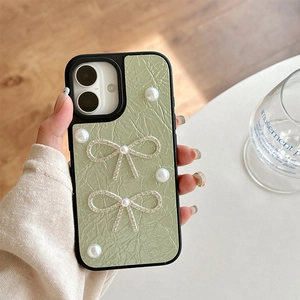 Close-up of light green textured iPhone case with pearl and silver rhinestone bows