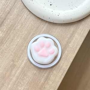 Detail shot of cute cat paw phone grip with soft pink silicone pads on wooden desk