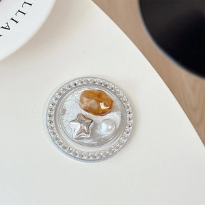 Detailed close-up of a luxury phone socket with rhinestones, pearls and amber star inlay