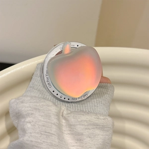 Macro detail of apple-shaped holographic phone grip with Gift For You engraved base