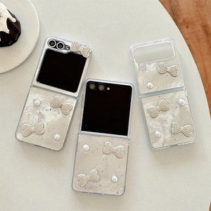 Pearlescent Z Flip case with pearl heart and crystal bow decoration on cream background