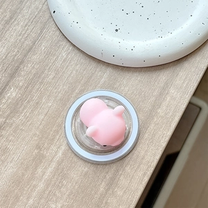 Detail of pink soft silicone squishy toy with cute animal face in transparent base