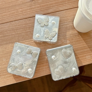 Detail of silver phone cases with pearl heart, bow, and butterfly crystal patterns