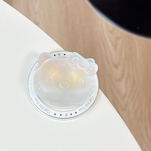Macro view of Hello Kitty shaped iridescent phone grip with a 3D pink bow on white surface