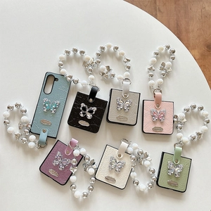 Foldable phone case with pleated leather texture, rhinestone butterfly, and pearl wrist strap