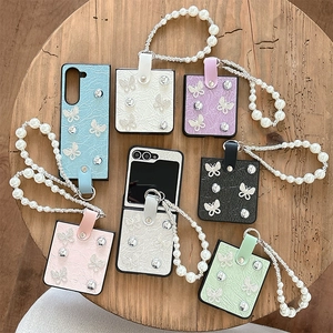 Foldable phone case with quilted leather texture, rhinestone butterfly, and pearl strap