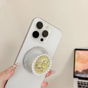 Round phone socket with pearls, rhinestones, and silver bow on a white smartphone