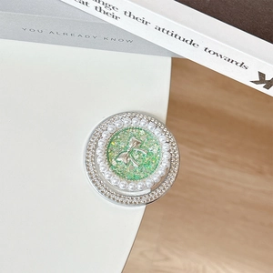 Macro detail of round phone socket with green glitter bow, pearls and rhinestones