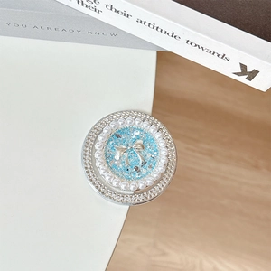Detail of blue glitter phone grip with silver bow, pearls, and double-layered rhinestones