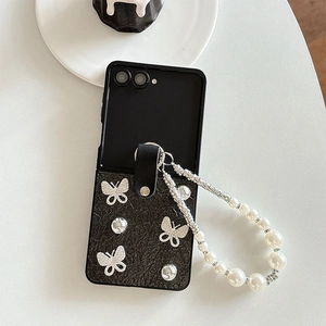 Detail of Galaxy Z Flip case with pearl bracelet and silver butterfly ornaments