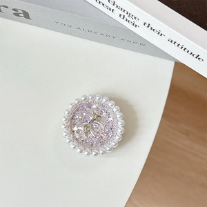 Detail of round phone socket with purple glitter, silver bow, and pearl border decoration