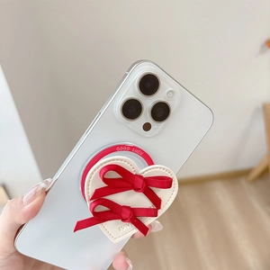 Detail of cream leather heart phone socket with red bows and Good Luck engraving