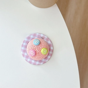 Macro shot of 3D pink checkered phone stand base with colorful letter M button details