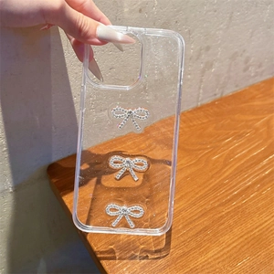 Clear glitter phone case for iPhone 16 Pro Max with silver rhinestone bow decorations