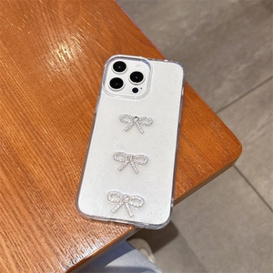 Close-up of glitter iPhone case featuring three silver rhinestone bowknot decorations