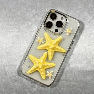 Detail of 3D yellow starfish ornaments and star glitters on transparent iPhone case