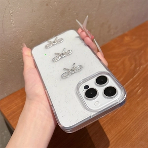 Detail of clear glitter phone case with three silver rhinestone bowknot decorations